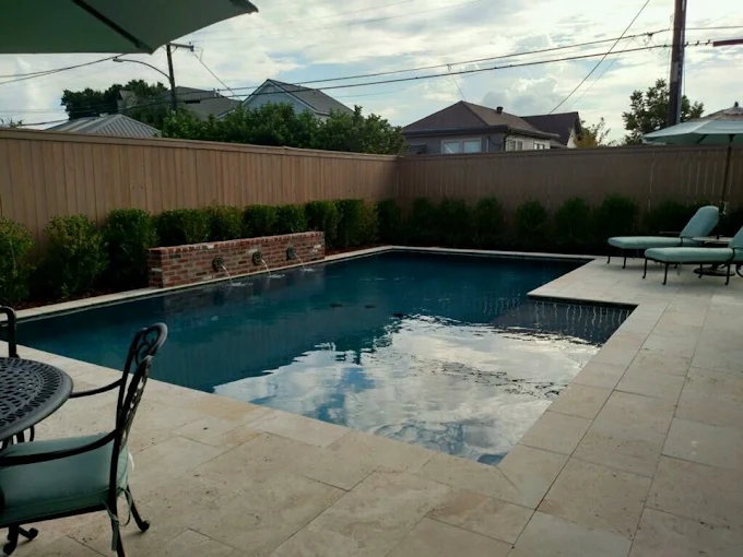 Rectangular pool with brick scupper water wall and travertine patio