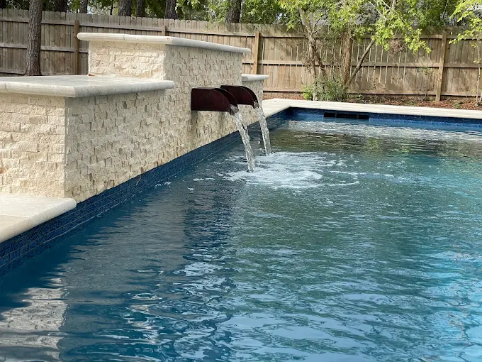 Stone water feature wall with scupper spillways into a pool