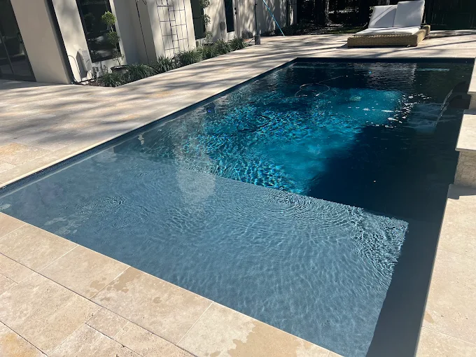 Sleek rectangular pool with tanning ledge and clean stone coping