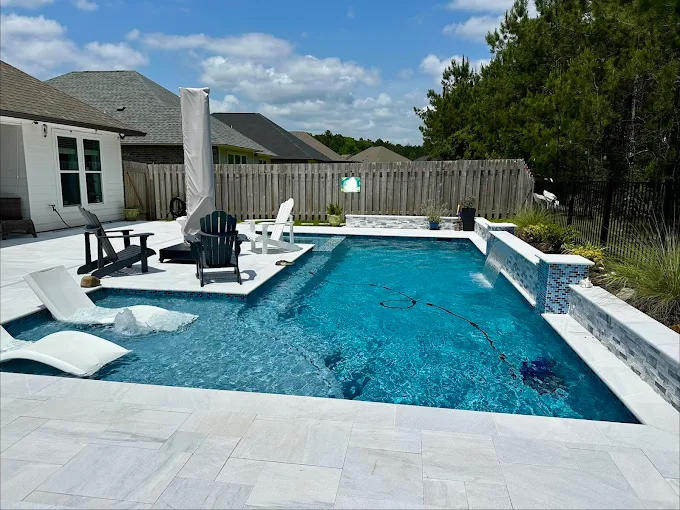 Modern pool with tanning ledge loungers and tile-faced raised wall